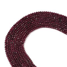 three strands of red glass beads on a white background