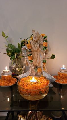 there is a bowl full of food on the table with candles in front of it