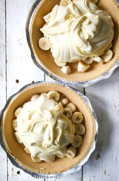 two pies with white frosting and bananas in them