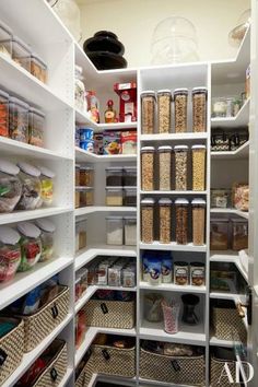 an organized pantry with white shelving and lots of food in the bins on shelves