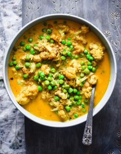 a bowl filled with cauliflower and peas