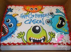 a birthday cake with monsters on it in a box