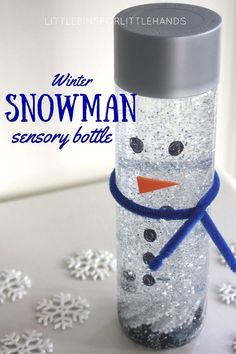 a snowman bottle sitting on top of a white table covered in snowflakes