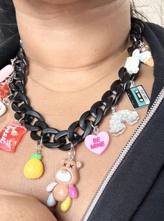 "🌈Introducing our chic matte black acrylic chain necklace with a delightful assortment of 11 charms that effortlessly blend resin, plastic, and metal elements.  🧸This statement piece boasts a unique combination of charms, including an adorable ice cream cone, whimsical unicorn, vintage tape with the message \"good vibes,\" tropical pineapple, and a vibrant 1.5-inch resin teddy bear.  🍍Each charm is thoughtfully chosen to create a playful yet sophisticated look. Elevate your style with this ve Cute Black Jewelry With Charms, Trendy Party Charm Necklaces, Trendy Charm Necklaces For Party, Trendy Black Charms Jewelry, Trendy Black Jewelry With Charms, Trendy Black Charm Necklace For Gifts, Trendy Black Charm Necklaces For Gifts, Trendy Black Charm Necklace For Party, Trendy Black Charm Necklace With Chain