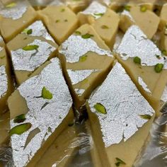 several pieces of cake sitting on top of tin foil covered in green and white toppings