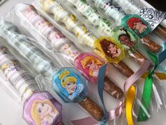 there are many different princesses on the table with some ribbons around them and wrapped in cellophane