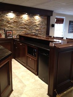 a kitchen with dark wood cabinets and granite counter tops, along with an island in the middle