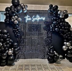 the entrance to the suppure is decorated with black and silver balloons