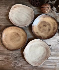 three brown plates sitting on top of a wooden table next to an acorn tree