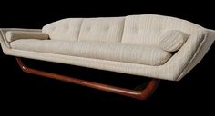 a white couch sitting on top of a wooden frame in front of a black background