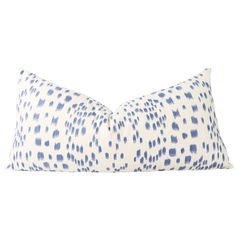 a blue and white pillow with spots on it's side, in front of a white background