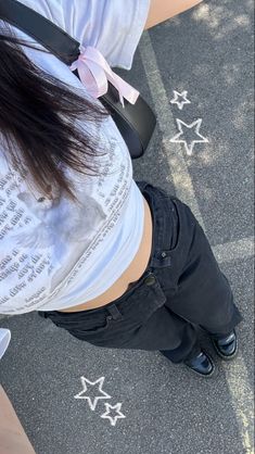 a woman standing in front of stars on the ground with her back to the camera