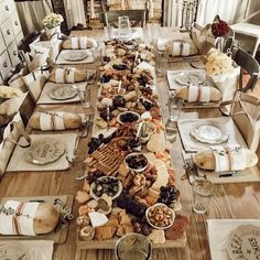 a long table covered in plates and bowls filled with different types of food on top of wooden tables