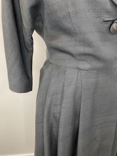 "Elegant black raw silk dress with great 1950s details. Lovely silhouette with one large button (and a bound buttonhole!) on the bodice as well as snaps and hooks inside. The collar and lapel are wide and fantastic. 3/4 dolman sleeve. Waist seam with pleats at the side front and back panels but flat in the front. The lining is a cheerful pale yellow silk. No label, handmade. Condition is great. The lining has some stains and discoloration as well as holes from wear and age under each underarm. R Vintage Silk Dresses For Work, 1950s Style Formal Dresses With Buttons, Vintage Evening Dress With Covered Buttons, Vintage Evening Dresses With Buttons, Raw Silk Dress, Black Suspenders, Yellow Silk, Suspender Skirt, Large Buttons