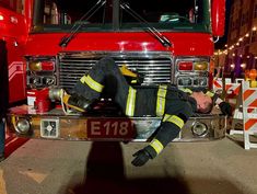 a fireman laying on the front of a fire truck