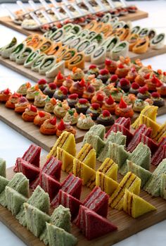 a variety of desserts are arranged on wooden trays and ready to be eaten