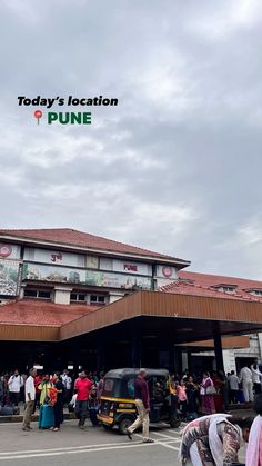 there is a large group of people standing in front of a building with a sign that says today's location pune