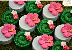 there are many cupcakes decorated with flowers on the top one is pink and green