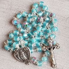 Light Blue Frosted Glass Bead Rosary Healing Rosary With Miraculous Medal And Round Beads, Healing Rosary With Miraculous Medal, Turquoise Rosary With Round Beads, Blue Rosary With Round Beads For Healing, Blue Rosary With 8mm Beads For Healing, Blue Rosary For Healing, Spiritual Blue Rosary With Round Beads, Spiritual Turquoise Rosary With Round Beads, Blue 108 Beads Spiritual Rosary