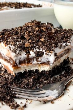 a piece of ice cream cake on a plate with a fork and glass of milk