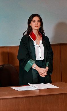 a woman standing in front of a wooden desk