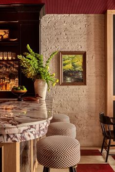 a bar with two stools and a potted plant