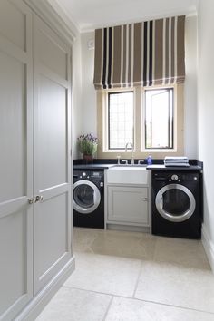 an image of a laundry room with washer and dryer in front of the window