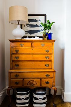 an old dresser with two black and white striped buckets on it's legs