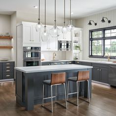 a large kitchen with an island and two bar stools