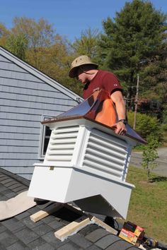 a man working on the roof of a house with an air conditioner attached to it