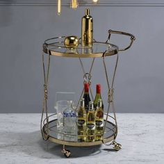 a bar cart with bottles and glasses on it