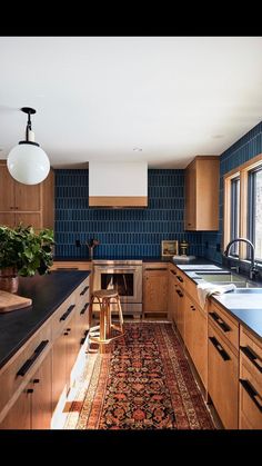 a kitchen with wooden cabinets and blue tile backsplash, an area rug on the floor