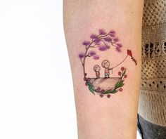 a couple holding hands while standing on top of a hill with trees and flowers around them