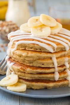 a stack of pancakes topped with bananas and icing