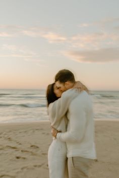 a man and woman kissing on the beach