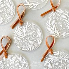 four christmas ornaments with ribbons on them