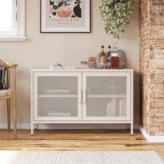 a white cabinet sitting in front of a brick wall