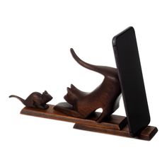 a wooden phone holder with a cat and mouse on it