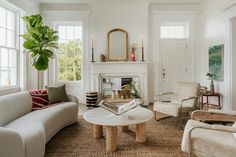 a living room with couches, chairs and a table in front of a fireplace