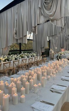 a long table with many white candles on it