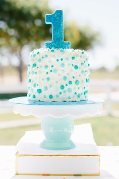 a blue and white birthday cake sitting on top of a table