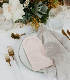 a table setting with flowers and silverware