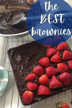 chocolate cake with strawberries on top and the words, the best brownies above it