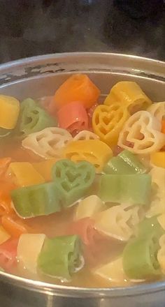 a metal pot filled with lots of different colored food items on top of a stove