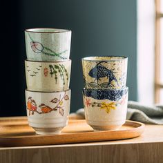 three cups sitting on top of a wooden table