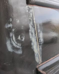 the side of a black truck with graffiti on it's face and door handle