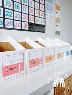 a group of boxes with numbers on them sitting in front of a wall mounted calendar