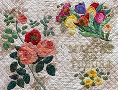 a quilted wall hanging with flowers and the words happy mom on it's side