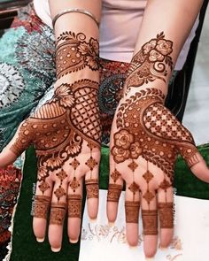 a woman's hands with hennap on it, showing the intricate design