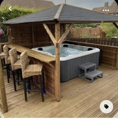 a hot tub sitting on top of a wooden deck next to a table and chairs